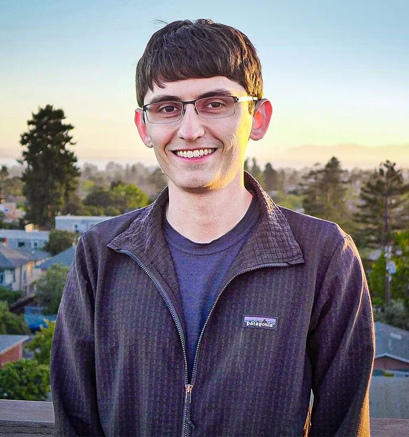 William Kretschmer standing on a balcony in a black sweatshirt.